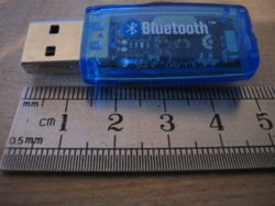 A typical Bluetooth USB dongle (BCM2045A), shown here next to a metric ruler