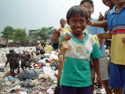 A boy from an East Cipinang trash dump slum in Jakarta, Indonesia  shows what he found.