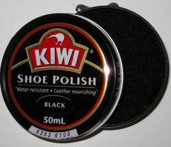 An open can of Kiwi shoe polish with a side-mounted opening mechanism visible at the top of the photo.