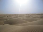The sun shines over Saharan dunes.