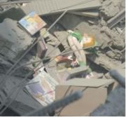 A doll and other toys amid the rubble of a destroyed house.