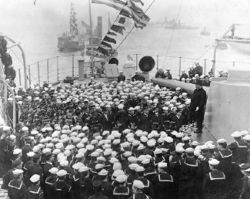  Roosevelt, (on the 12" gun turret at right), addresses the crew of USS Connecticut (BB18), in Hampton Roads, Virginia, upon her return from the Fleet's cruise
