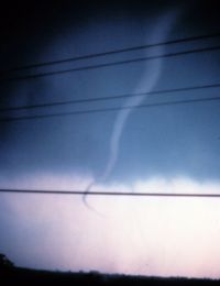 A rope tornado in its dissipating stage.  The horizontal lines in the foreground are power cables.