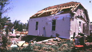 An example of F1 damage.  F1 tornadoes cause major damage to mobile homes and automobiles, and can cause minor structural damage to well-constructed homes.  This particular mobile home appears to be a double-wide, and it was still moved off its foundations, with its roof badly damaged.  A mobile home or car is a very poor shelter, even during severe thunderstorms which do not contain a tornado.
