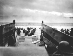 American troops disembark in the surf at Omaha Beach on D-Day, 6 June 1944.