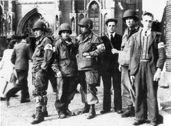 Members of the Dutch Eindhoven Resistance with troops of the U.S. 101st Airborne in front of the Eindhoven cathedral during Operation Market Garden in September 1944.