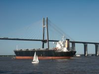A cargo ship in front of the Rosario-Victoria Bridge