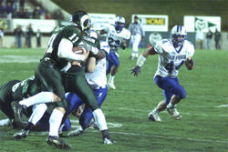A Colorado State University player runs with the ball as an Air Force Academy player lines up a tackle.