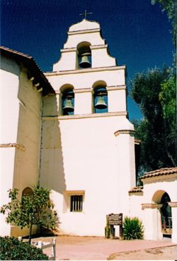 The three-bell campanario ("bell wall") at Mission San Juan Bautista. Two of the bells were salvaged from the original chime, which was destoyed in the 1906 San Francisco earthquake.