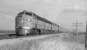 Train No. 107, the Challenger, is led by a Chicago and North Western Railway EMD E8 locomotive as it passes east of Ames, Iowa on November 23, 1954.