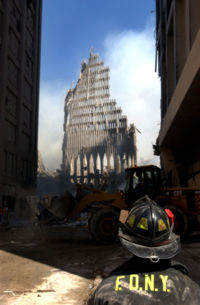A New York City firefighter looks up at the remains of the World Trade Center