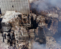Portions of the outer shell of the North Tower leans against the remains of WTC6 which suffered massive damage when the North Tower collapsed. The remains of WTC7 are at upper right