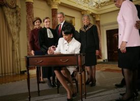 Secretary of State Dr. Condoleezza Rice signs official papers after receiving the oath of office during her ceremonial swearing in at the Department of State. Watching on are, from left, Laura Bush, Justice Ruth Bader Ginsburg, President George W. Bush and an unidentified family member.