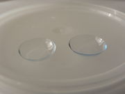 A pair of contact lenses when not inserted in the eye. They are positioned with the concave side facing upward.
