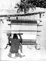 Hopi man weaving on traditional loom in the USA.