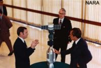  Lunney (left) shows President Nixon a model of the Apollo and Soyuz spacecraft docked during a tour of the Johnson Space Center, March 20, 1974.