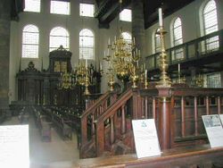 Interior of the Esnoga synagogue in Amsterdam. The tebáh (reader’s platform) in the foreground, and the Hekhál (Ark) is in the background.