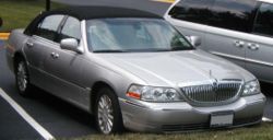 2003 Lincoln Town Car with minor changes to the front fascia including a new grille and HID headlights. Also visible in the picture is the return of the hood ornament as well as one of the new 17 inch wheel choices.