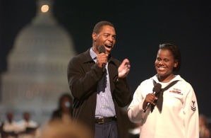 Marcus Allen with Yeoman 2nd Class Katherine Ward introduce Aretha Franklin during a concert in tribute to U.S. military members on the National Mall, September 4, 2003