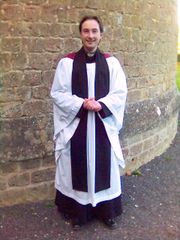 A priest in Anglican choir habit.  Normally worn at non-Eucharistic liturgies and offices, the vesture is also worn by many "low church" or evangelical Anglicans to preside at the Eucharist