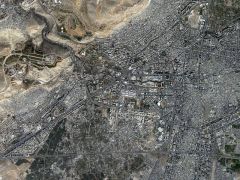 Satellite image of Damascus, with Umaween Square just above the centre. The Barada river can be seen entering the picture in the upper left corner, and the western half of the old city is in the centre of the right hand edge of the photograph. The modern district of Mezze extends north of the motorway on the centre of the left edge.