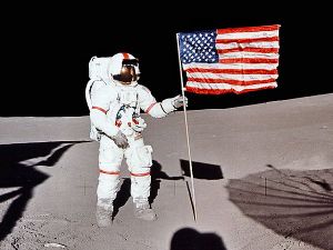 Astronaut Alan Shepard raises the Flag of the United States on the surface of the Moon.