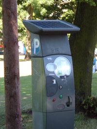 A solar panel on top of a parking meter.  Note that this particular installation is shaded, and may not perform as desired.