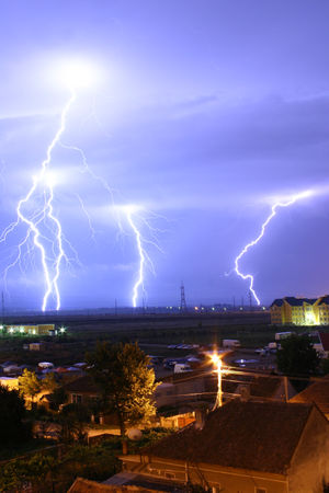 Lightning is an example of plasma present at Earth's surface. Typically, lightning discharges 30,000 amperes, at up to 100 million volts, and emits light, radio waves, x-rays and even gamma rays . Plasma temperatures in lightning can approach 28,000 Kelvin and electron densities may exceed 1024/m3.