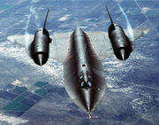 An air-to-air overhead front view of an SR-71A strategic reconnaissance aircraft. Note the water vapor, condensed by the low-pressure vortices generated by the chines ouboard of each engine inlet.