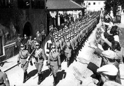 German troops march into Austria on 12 March 1938.