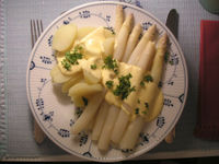 Hollandaise sauce served over white asparagus and potatoes.
