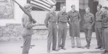 Members of the Prominente, under a U.S. guard, outside the Hungerberg Hotel on May 5, 1945, shortly after their release. L to R: John Alexander Elphinstone, Max de Hamel, Michael Alexander, unknown, George Lascelles, and John Winant Jr..