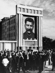 Large image of Joseph Stalin looms over Soviets.