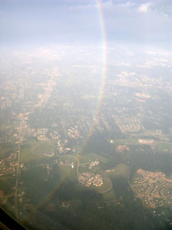 A portion of a 360 degree rainbow, seen from an airplane.