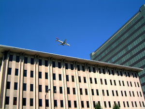A passenger jet flying over Downtown on its approach to Mineta San Jose International