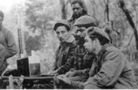 Listening to a Zenith "TransOceanic" shortwave receiver are (seated from the left) Rogelio Oliva, José María Martínez Tamayo (known as "Mbili" in the Congo and "Ricardo" in Bolivia), and Guevara. Standing behind them is Roberto Sánchez ("Lawton" in Cuba and "Changa" in the Congo).