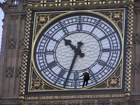 The massive clock on Big Ben, London, England. The  5 foot 4 inch (1.63 m) person "holding on" to the six-o'clock marking has been inserted into the picture at correct scale. The hour hand is 9 feet (2.7 m) long, and the minute hand is 14 feet (4.3 m) long.