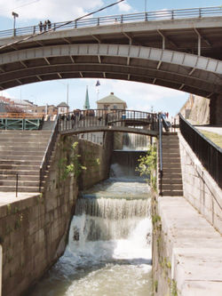 Original five step lock structure crossing the Niagara Escarpment at Lockport, now without gates and used as a cascade for excess water. A modern 40-foot-wide (12 meter) single-step lock is to the left, replacing another original five-step lock.