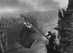 Red Army soldiers raising the Soviet flag on the roof of the Reichstag in Berlin, Germany