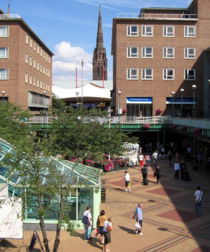 The Precinct in Coventry city centre.  The spire of the ruined cathedral is visible in the background.