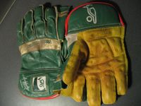 A pair of wicket-keeping gloves. The webbing which helps the wicket-keeper to catch the ball can be seen between the thumb and index fingers.