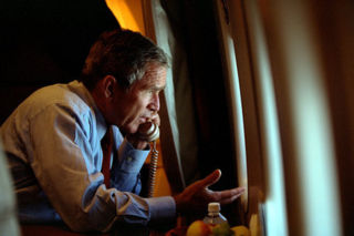 President Bush talks on the phone with Vice President Dick Cheney while looking out a window of Air Force One, September 11, 2001.