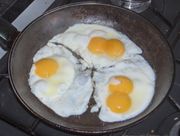 Three eggs frying, two of which are double-yolked eggs.