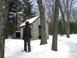 A reproduction of Thoreau’s cabin with a statue of Thoreau