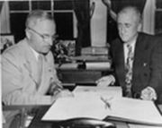 Truman signs U.N. charter as Secretary of State James F. Byrnes looks on