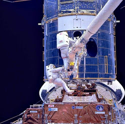 Astronauts work on Hubble during the first servicing mission.