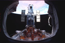  Hubble on the payload bay just prior to release with beautiful glowing color of earth in the background. SM3B : STS-109.