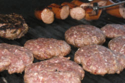 Various meats being cooked on a barbeque.