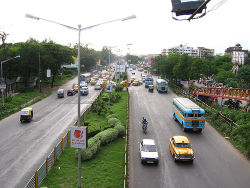 Bus, yellow cabs, auto rickshaws and other vehicles in Kolkata traffic.