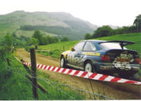A Ford Escort Cosworth, driven by Malcolm Wilson on a stage rally.